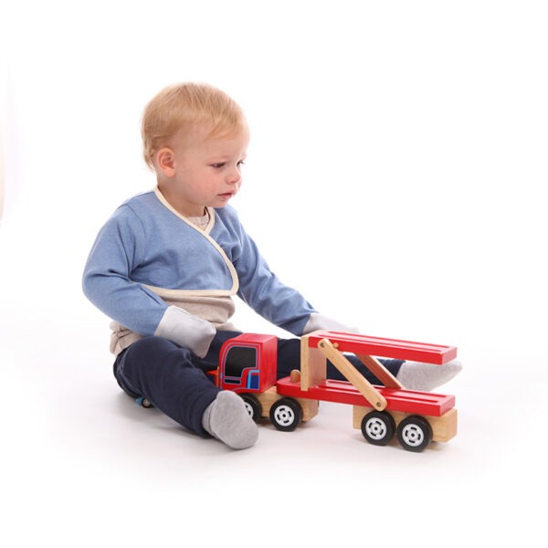 Little boy sat on floor playing with toys, wearing t-shirt, trousers and children's bolero style blue marl cross-over ScratchSleeves. Shows children can still play and use their hands naturally while their hands are covered by the silk mitts. Also shows that the ScratchSleeves can be worn comfortably over clothing and the cross-over front holds them firmly in place.