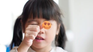 Girls showing camera the reward chart sticker on her thumb